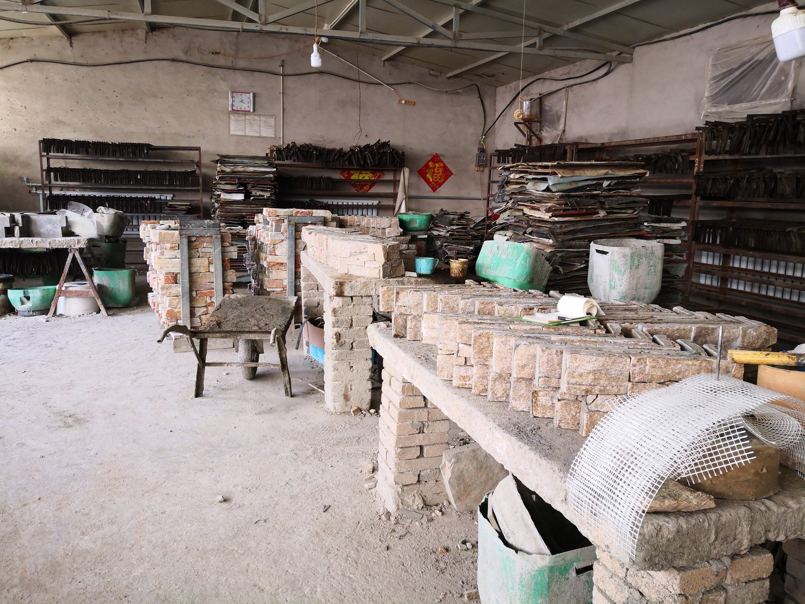 Factory workers assembling cement backed stone veneer panels under QC supervision