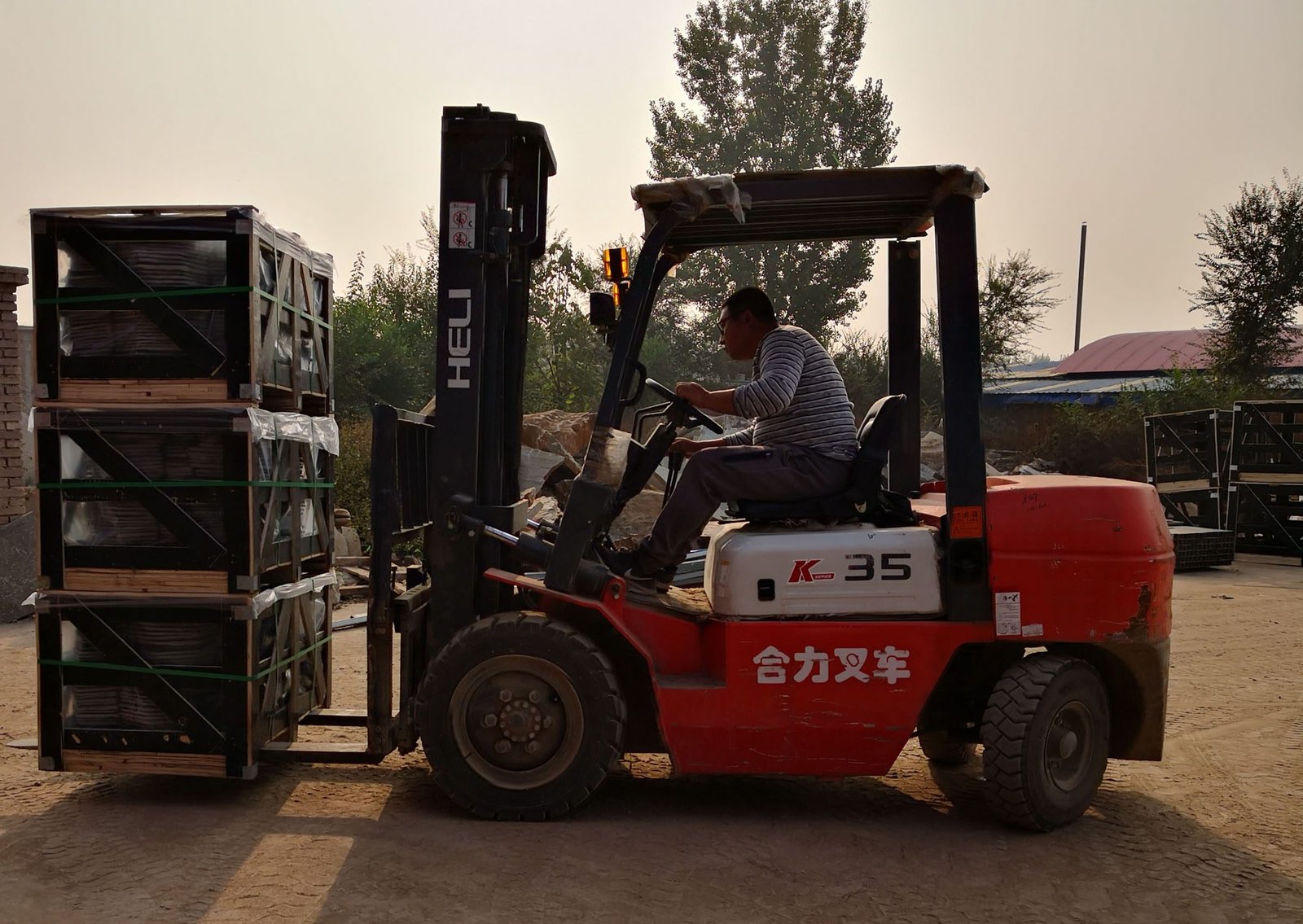 forklift transporting wooden pallets of stone cladding - inventory holding cost is priced into stone veneer retail markup