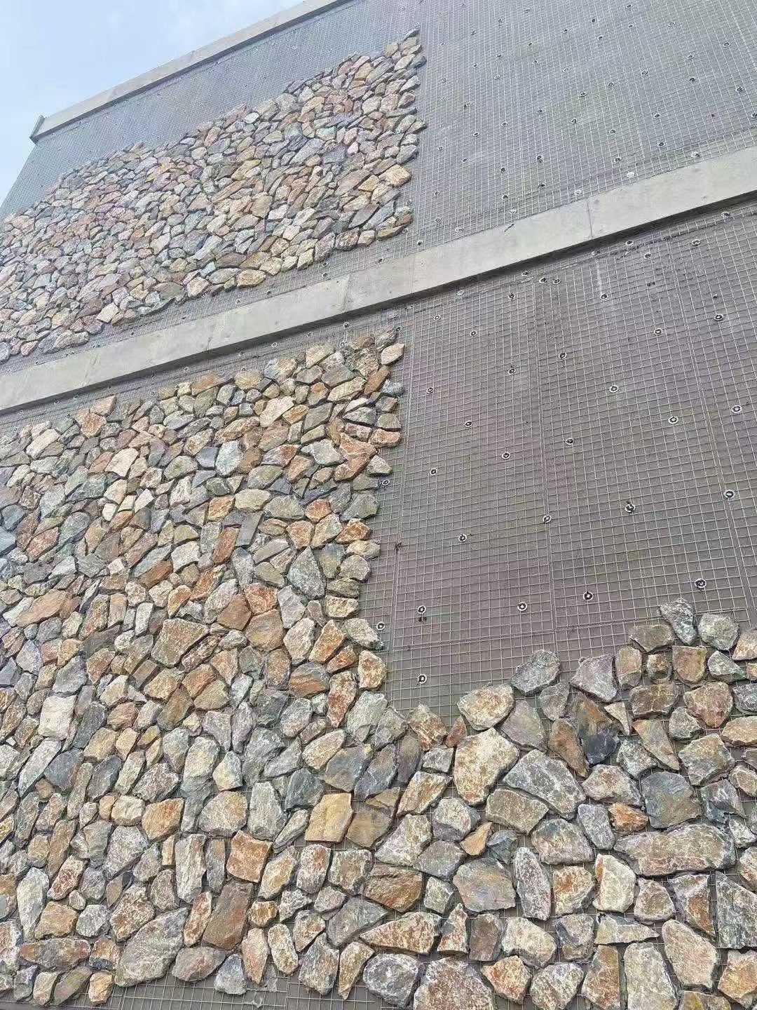 loose thin stone veneer application on a prepared exterior wall face, low areal mass suitable for building over sound render, natural split face texture - photo 8