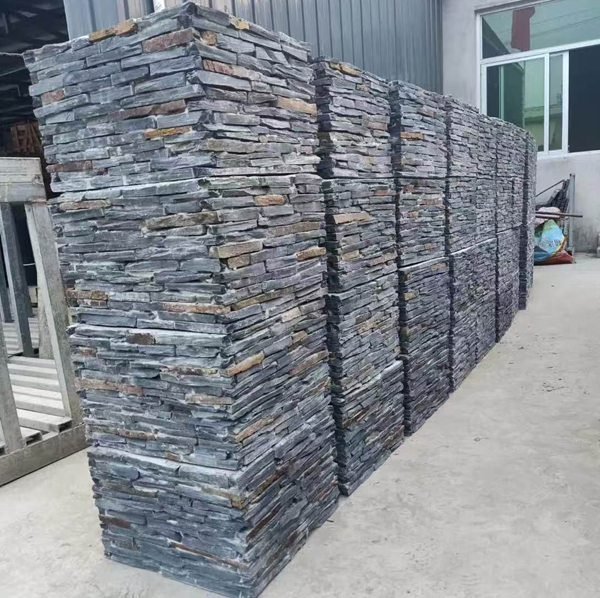 Factory workers assembling stacked stone column sections under QC supervision