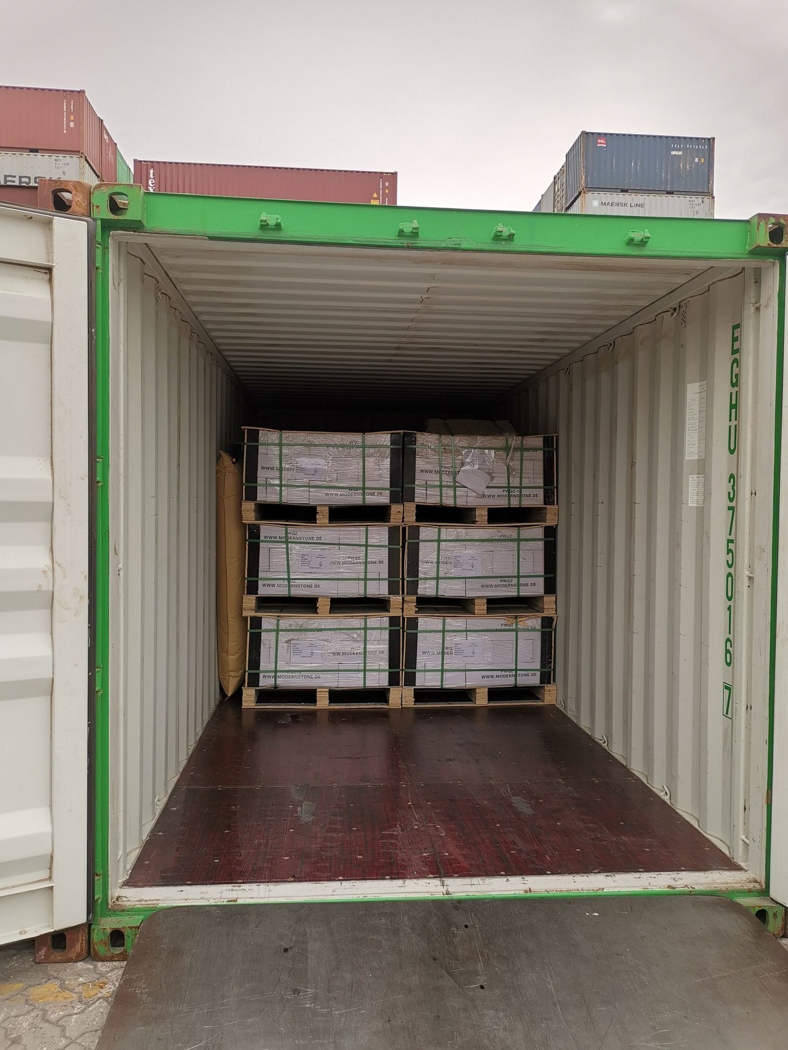 Wooden crates of stone panels secured inside container