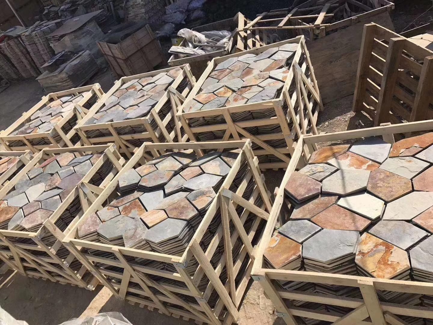 Steel-strapped pallets of flagstone staged for container loading