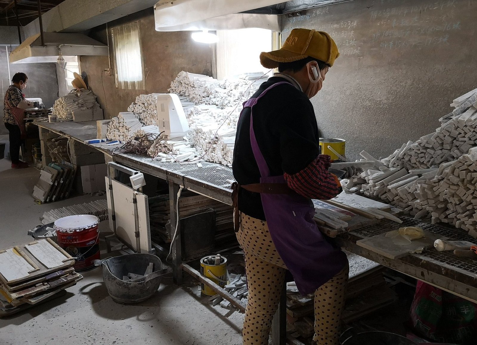 workers hand assembling natural stone split face panels at Chinese stone factory production line