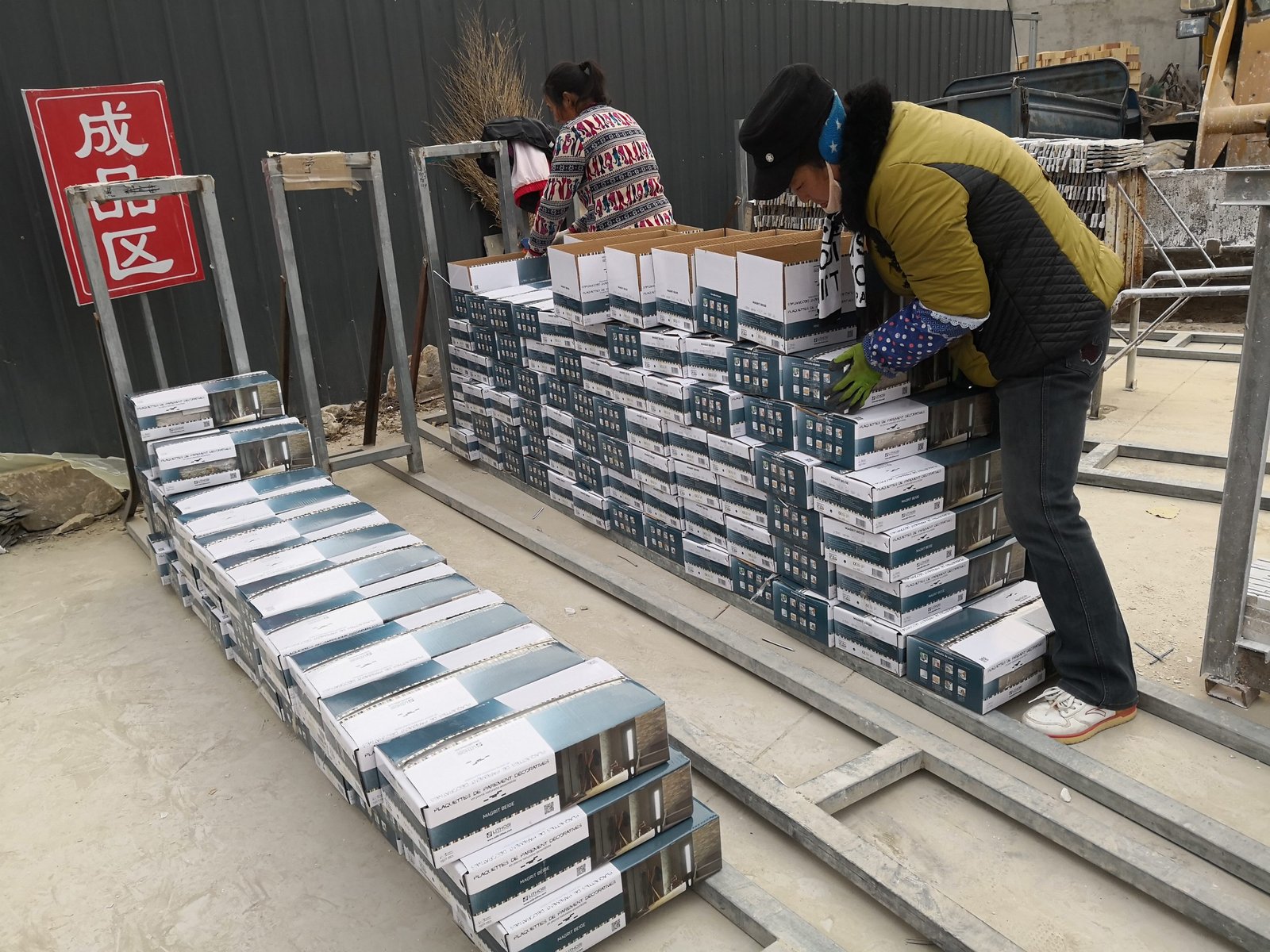 workers stacking stone boxes on export wooden pallet